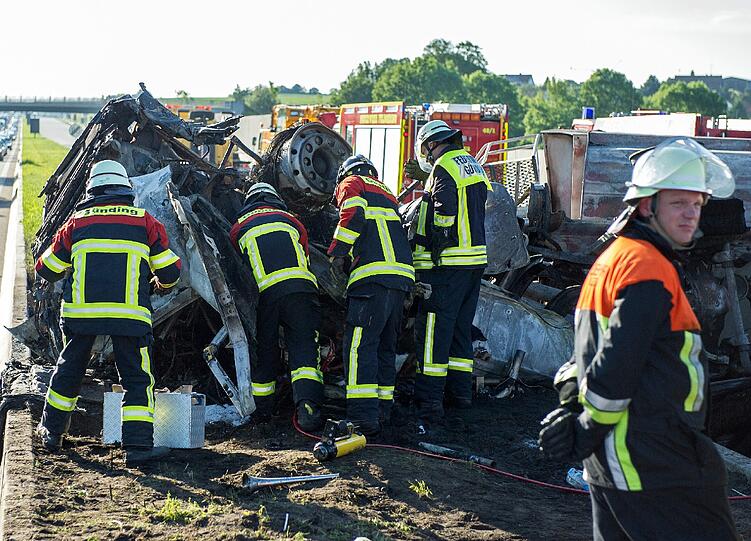 Rettungskräfte auf der Autobahn A8 bei Sulzemoos (Oberbayern) an einem ausgebrannten Lastwagen. Zwei weitere Autos sind in den Auflieger des Lastwagens gefahren. Bei dem Unfall kam mindestens eine Person ums Leben.