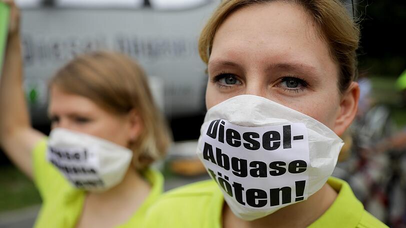 Eine Frau trägt bei einer Anti-Diesel-Demonstration einen Mundschutz.