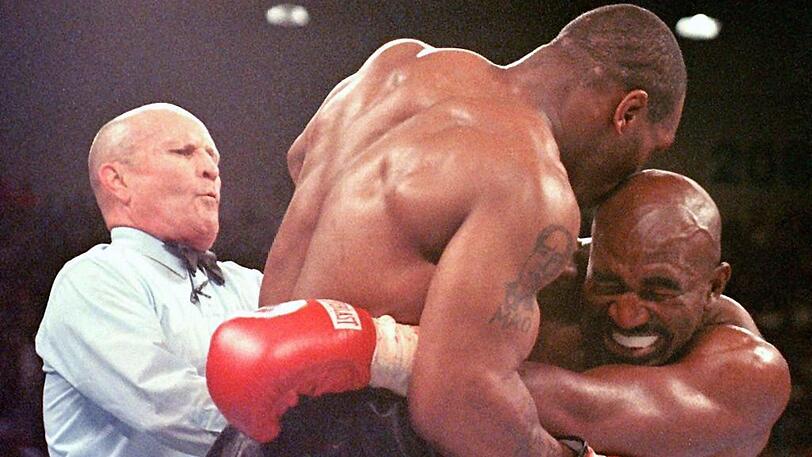 Einer seiner vielen Skandale: Tyson (l.) beißt Evander Holyfield im WM-Kampf 1997 ein Stück des Ohres ab.