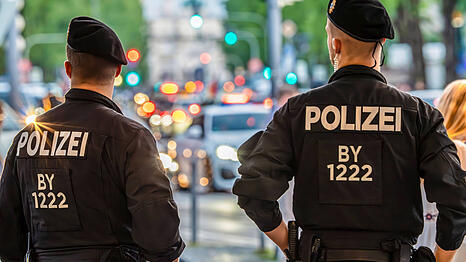 Polizisten beobachten feiernde Fußball-Fans. In diesem Fall während der Fußball-EM 2024.