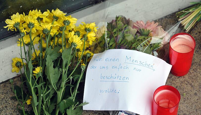"Für einen Menschen, der einfach nur beschützen wollte": Blumen und Kerzen liegen in Augsburg vor der Polizeistation.