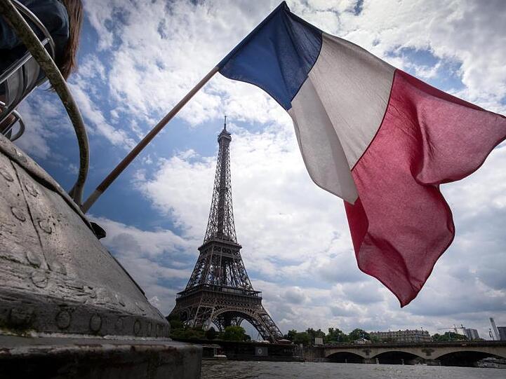 Die französische Flagge vor dem Eiffelturm: Die Wirtschaft des Landes konnte im vergangenen Jahr ein moderates Wachstum verzeichnen.