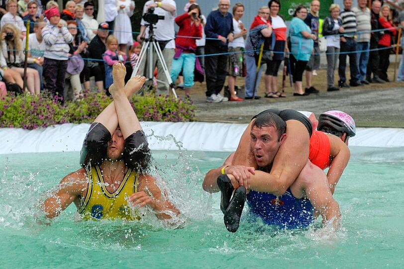 Beim "Wife-Carrying-Event" in Finnland müssen die Männer ihre Frauen über ein Strecke mit vielen Hindernissen tragen.Die spinnen die Finnen."Wife Carrying" in Finnland.