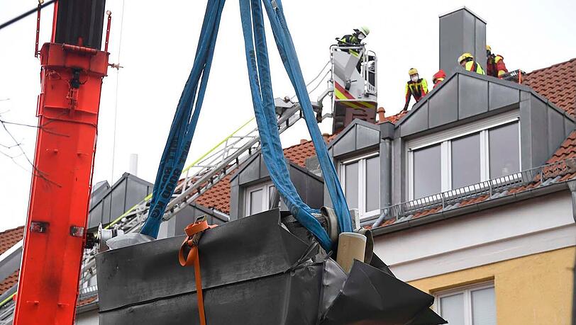 Mit Hilfe eines 50-Tonnen-Krans brachte die Feuerwehr den Kamin sicher auf den Boden. Mit Hilfe eines 50-Tonnen-Krans brachte die Feuerwehr den Kamin sicher auf den Boden.