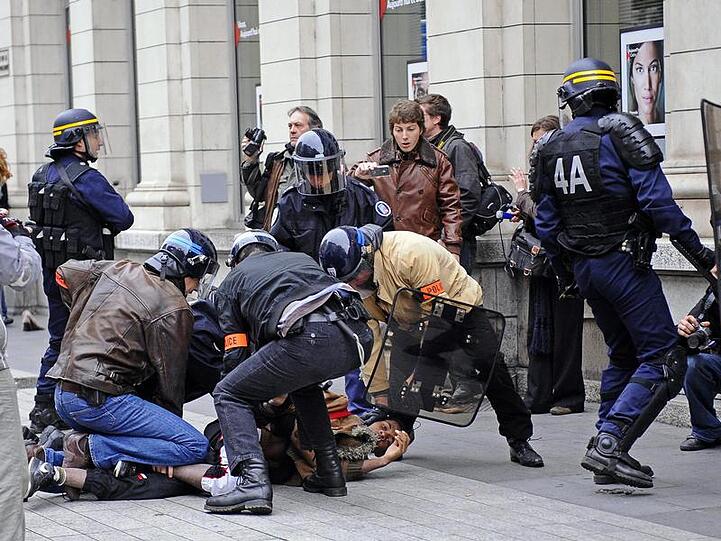 Polizisten nehmen bei einer Demonstration in Lyon einen Studenten fest.