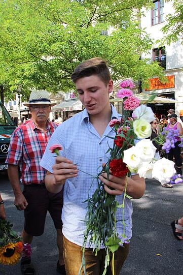 Hier werden Nelken und Rosen an die Münchner verschenkt.