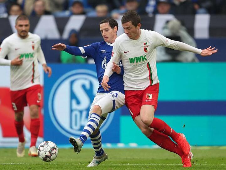 Schalkes Sebastian Rudy (l) spitzelt den Ball vor Augsburgs Michael Gregoritsch weg.