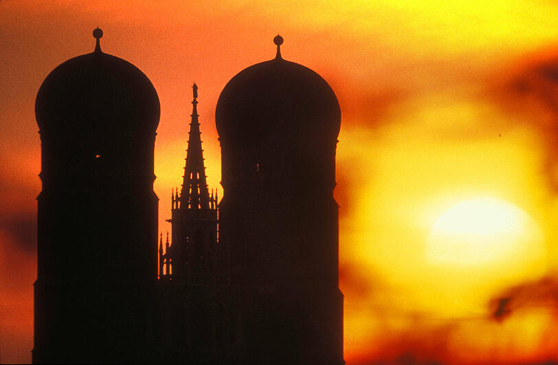 Sahara-Staub beim Sonnenaufgang über München: Frauenkirche und Rathaus.