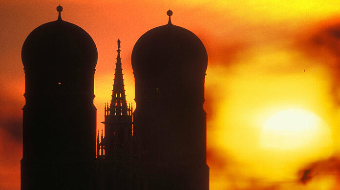 Sahara-Staub beim Sonnenaufgang über München: Frauenkirche und Rathaus.