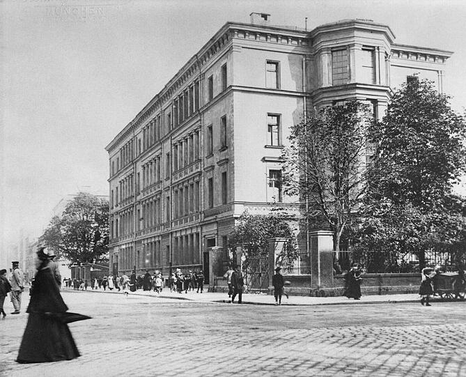 Die Türkenschule an der Ecke Schelling-/Türkenstraße. Die gibt es heute auch noch. Sie schaut allerdings ein bisserl weniger streng aus - genau wie die Menschen, die davor spazieren gehen. Aufnahme um 1905.