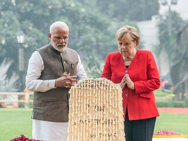 An dem Ort, an dem Gandhi erschossen wurde, faltet Angela Merkel neben Premier Narendra Modi ihre Hände zum Gedenken.