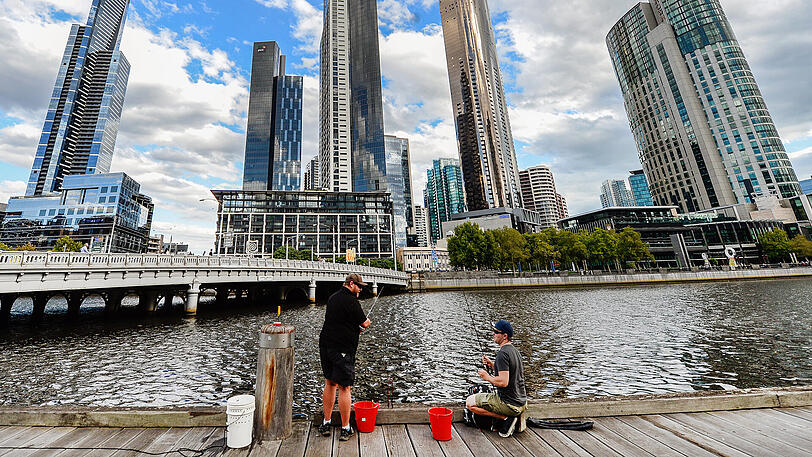 Angler sitzen vor der Skyline von Melbourne, Australien.