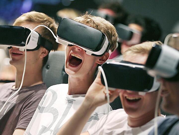 Besucher der Gamescom tauchen mittels VR-Brillen in ein Computerspiel ein.