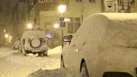 Schnee bedeckt am frühen Morgen eine Straße und die Autos am Straßenrand. Tief Tristan hat für gewaltige Schneemengen im Harz wie hier in Wernigerode gesorgt.