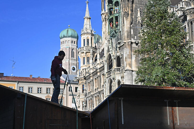 Arbeiter bauen die Standl für den Christkindlmarkt am Marienplatz auf.