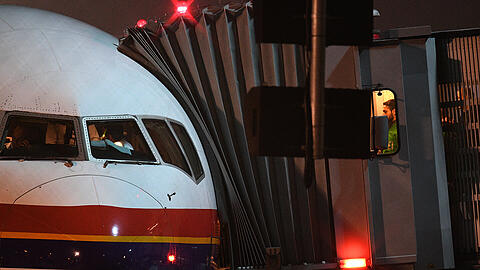 Polizisten betreten ein Flugzeug von Meridiana