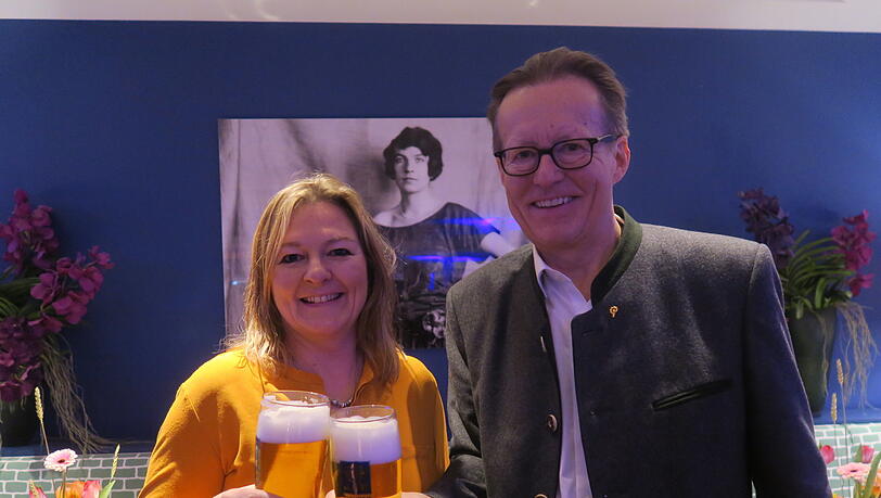 Ein Prost auf die Stiftungs-Gründerin Edith Haberland, die auf dem Bild im Hintergrund zu sehen ist. Vorne stoßen Wiesn-Stadträtin Anja Berger (Grüne) und Augustiner-Chef Martin Leibhard mit einem frisch gezapften Augustiner an.