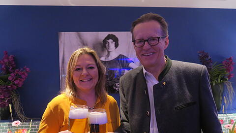 Ein Prost auf die Stiftungs-Gründerin Edith Haberland, die auf dem Bild im Hintergrund zu sehen ist. Vorne stoßen Wiesn-Stadträtin Anja Berger (Grüne) und Augustiner-Chef Martin Leibhard mit einem frisch gezapften Augustiner an.