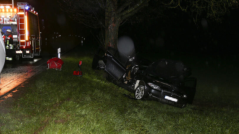 Schreckliche Bilder aus Icking: Der BMW kam von der Straße ab und prallte gegen einen Baum. Zwei 19-jährige Männer starben.