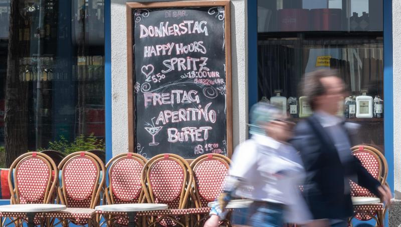 Passanten gehen an zusammengestellten Tischen und Stühlen eines geschlossenen Cafes vorbei. Foto: Peter Kneffel/dpa/Archivbild Passanten gehen an zusammengestellten Tischen und Stühlen eines geschlossenen Cafes vorbei. Foto: Peter Kneffel/dpa/Archivbild