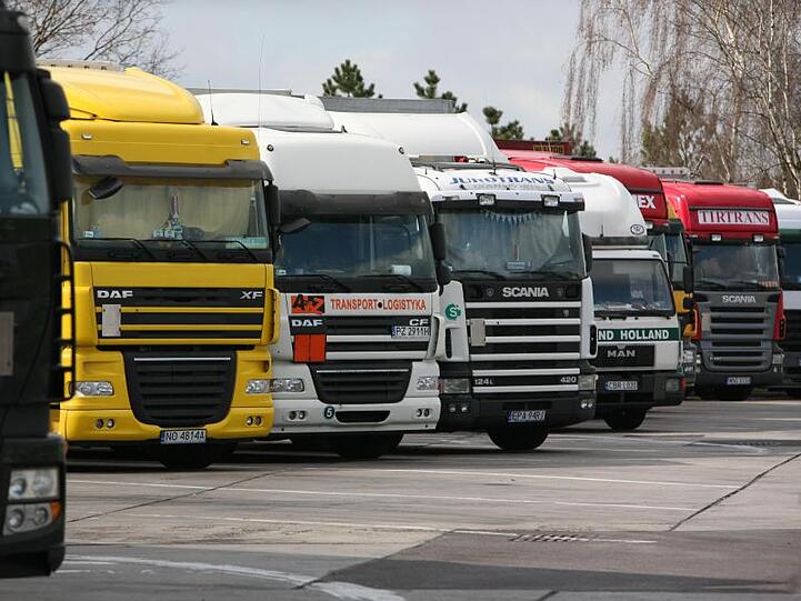 Verchiedene Lastwagen parken an einer Raststätte.