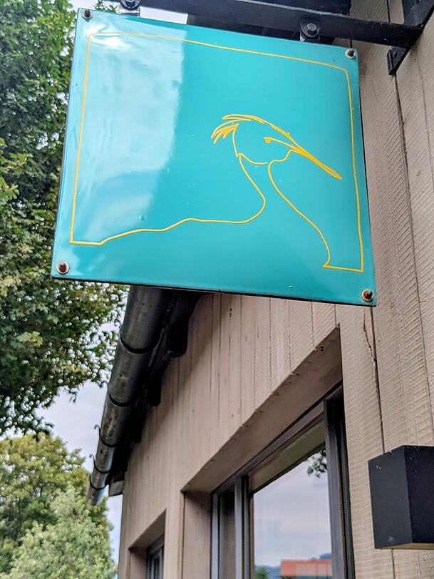 Der Wasservogel Haubentaucher ist Namensgeber und auch drau&szlig;en auf dem Schild zu sehen.