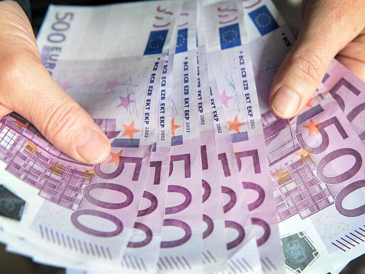 Eine Frau zählt 500-Euro-Geldscheine. Foto: Patrick Seeger/Archiv