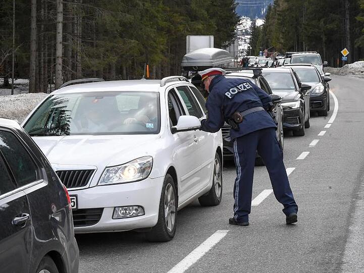 Polizisten kontrollieren Personen in St. Anton am Arlberg in den Tiroler Alpen.