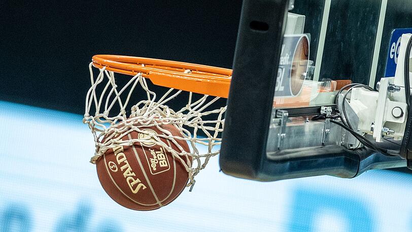 Ein Basketball landet im Korb.