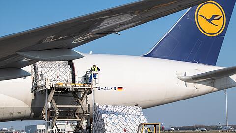Ein Frachtflugzeug der Lufthansa Cargo wird auf dem Vorfeld vom Flughafen München entladen.