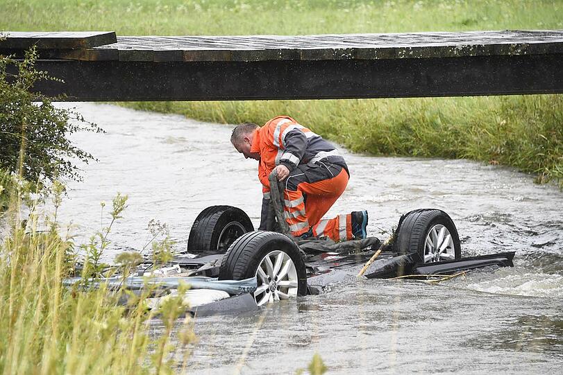 Bei Bayerischzell am Schliersee landet ein Passat kopfüber in einem stark überfluteten Bach. Der Fahrer kann in letzter Sekunde gerettet werden. Die Bilder des Unfalls.