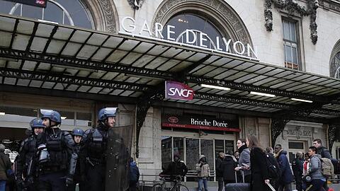 Reisende am Gare de Lyon, der während einer Demonstration der streikenden Eisenbahner von Polizisten bewacht wird.