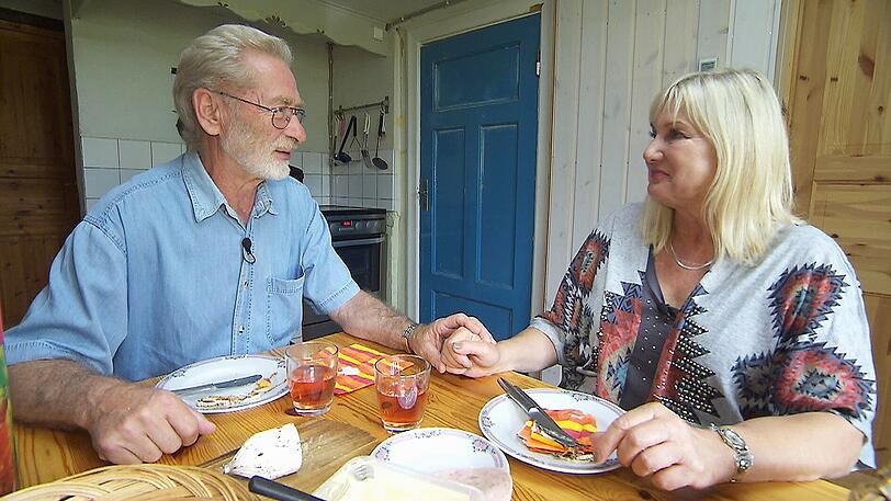 Fritz (69), der herzliche Hobbybauer, begrüßt Ingrid (63) zur Hofwoche in Schweden. Nach dem herzlichen Wiedersehen bereitet Fritz ein Abendbrot und ist einfach nur glücklich.