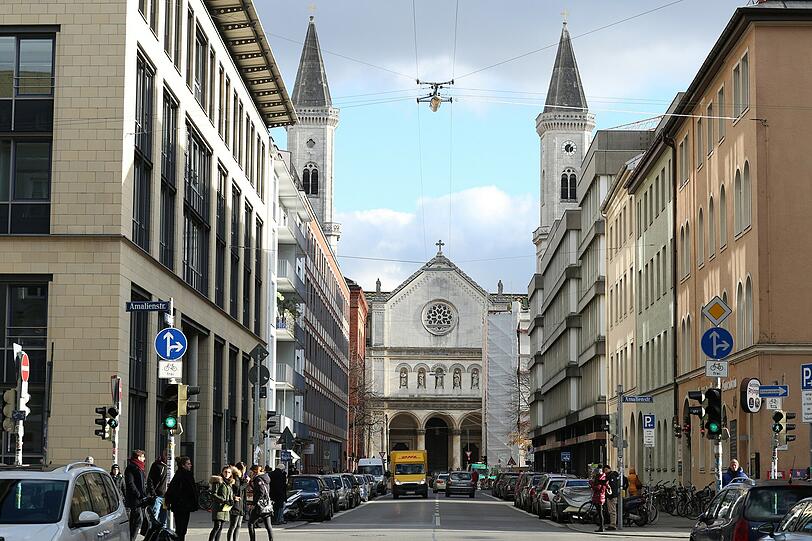Und zwischen den Türmen blitzt es blau: Ein Blick aus der Schellingstraße Richtung Ludwigstraße, am Ende die Kirche St. Ludwig.
