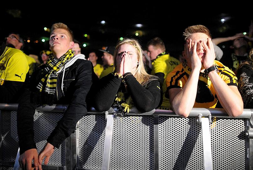 Traurig und niedergeschlagen: Die Fans des BVB sahen ein großartiges Spiel ihrer Mannschaft. Aber Arjen Robben machte in der 89. Minute mit dem Siegtreffer alle gelben Träume zunichte. Die Bilder von der Fanmeile in Dortmund.