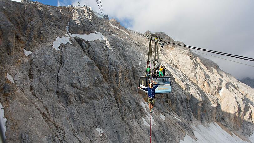 Atemberaubende Bilder. Alexander Schulz (23) aus Rosenheim ist in schwindelerregender Höhe über eine Slackline zwischen zwei Zugspitz-Gondeln hin und her balanciert. Atemberaubende Bilder. Alexander Schulz (23) aus Rosenheim ist in schwindelerregender Höhe über eine Slackline zwischen zwei Zugspitz-Gondeln hin und her balanciert.