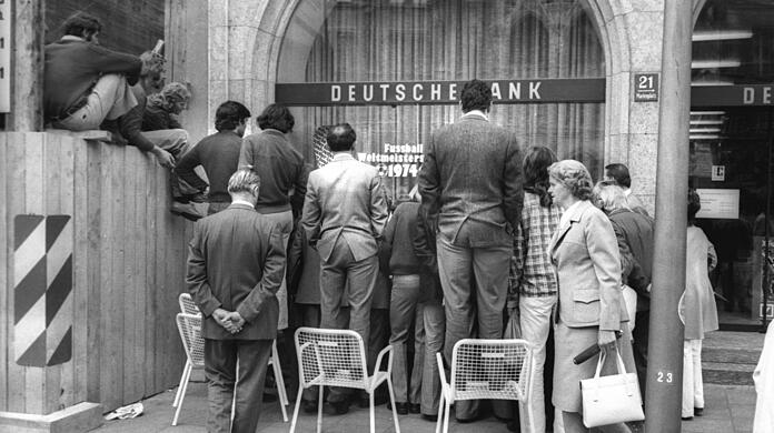 Eine Bank zeigt Herz für Fußball-Fans: Die Plätze vor dem Schaufenster am Marienplatz sind begehrt. Ton gibt's freilich keinen.