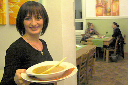 Genuss mit Kunst aus der Region: Bedienung Nadja serviert Kürbissuppe vor [BU]der bunten Kulisse des &bdquo; Chesmu&ldquo;.