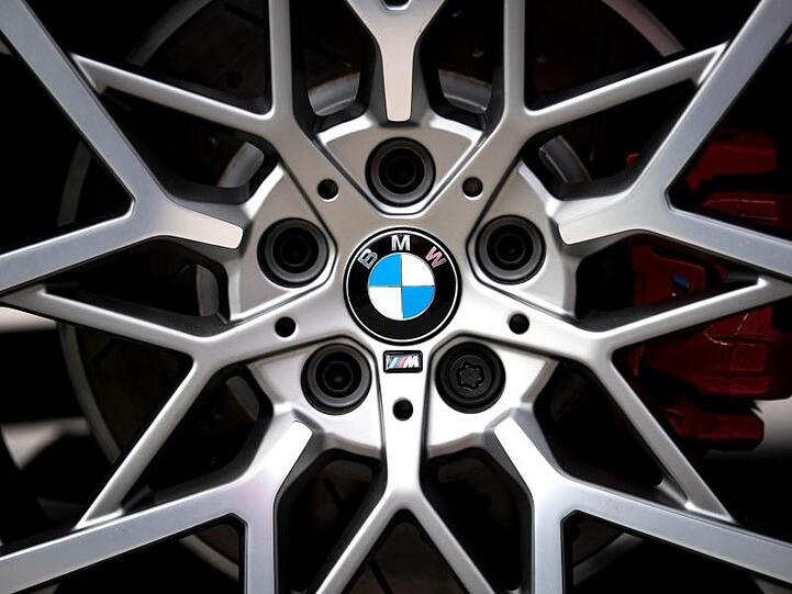 Das Logo des Münchner Autobauers BMW ist auf den Felgen eines Autos zu sehen. Foto: Sina Schuldt/dpa/Archivbild