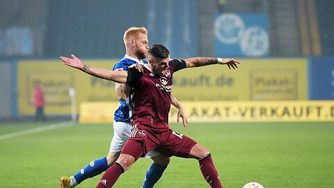 Nürnbergs Erik Wekesser (r) blockt den Ball gegen Rostocks Nils Fröling.