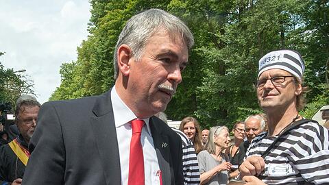 Gustl Mollath geht am 07.07.2014 neben einem als Sträfling verkleideten Unterstützer vor dem Landgericht in Regensburg. Knapp ein Jahr nach seiner Entlassung aus der Psychiatrie steht Mollath erneut vor Gericht.