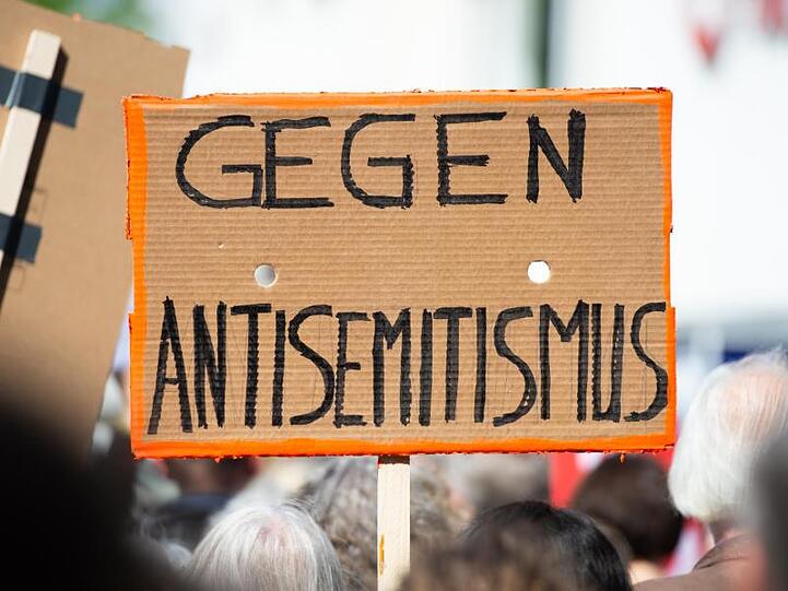 Ein Plakat hält auf einer Kundgebung gegen Antisemitismus mit der Aufschrift "Gegen Antisemitismus". Foto: Christophe Gateau/dpa