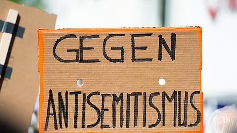 Ein Plakat hält auf einer Kundgebung gegen Antisemitismus mit der Aufschrift "Gegen Antisemitismus". Foto: Christophe Gateau/dpa