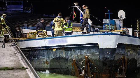 Einsatzkr&auml;fte brachten vorsorglich eine &Ouml;lsperre an dem havarierten Schiff an.