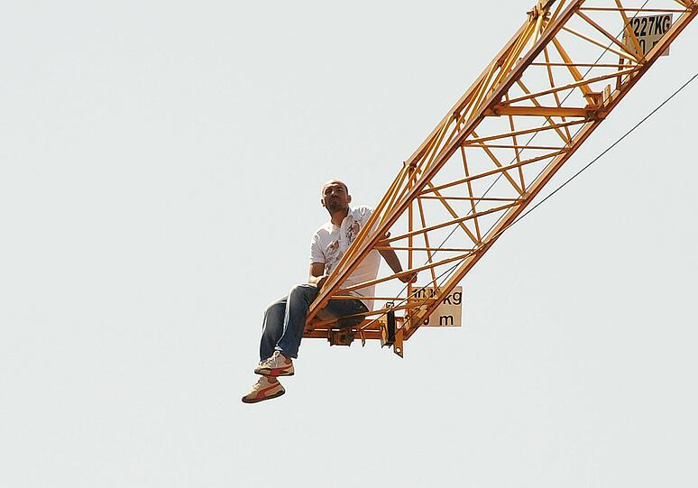 Ein Mann auf einem Kran hält die Münchner Einsatzkräfte in Atem. Die Bilder