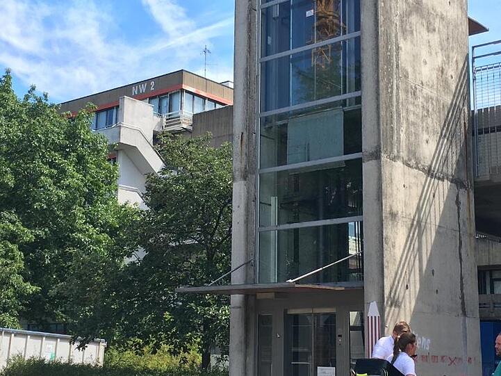 Rettunskräfte und Polizisten stehen auf dem Gelände der Bremer Universität zusammen. In Bremen ist ein Mann nach einer Gewalttat auf das Dach eines Universitätsgebäudes geflohen.