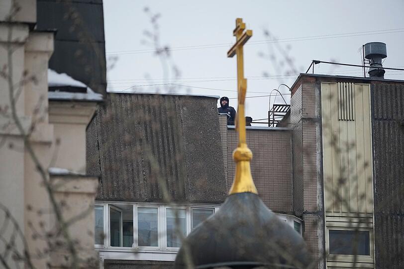 Polizisten stehen in Moskau auf dem Dach eines Wohnhauses in der Nähe der Kirche, in der Kremlgegner Alexej Nawalny heute beigesetzt werden soll. Befürchtet wird, dass der russische Machtapparat hart gegen Nawalnys Unterstützer vorgehen wird.