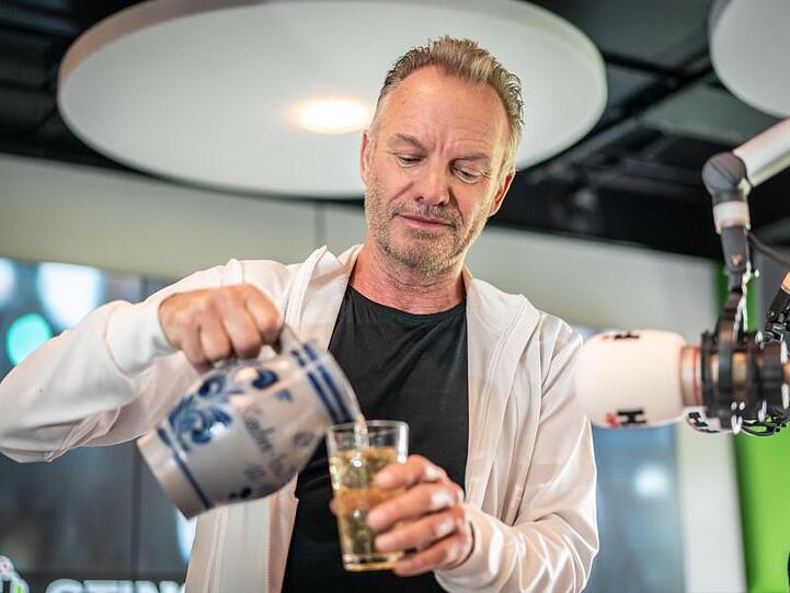 Sting besucht Radio FFH und gießt sich ein Glas hessischen Apfelwein ein.