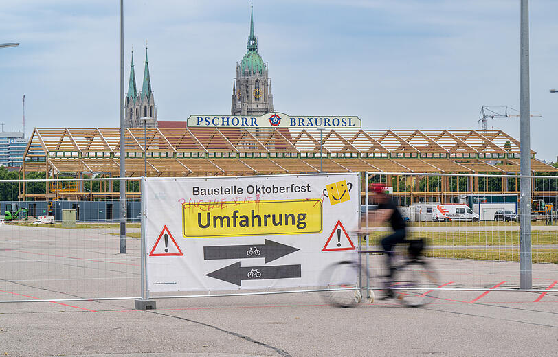 Ein Plakat mit der Aufschrift "Umfahrung" hängt zu Beginn des offiziellen Start zum Oktoberfest-Aufbau an einem Tor des ansonsten eingezäunten Wiesn-Gelände.
