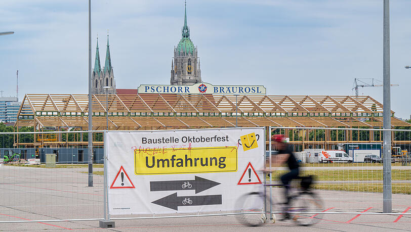 Ein Plakat mit der Aufschrift "Umfahrung" hängt zu Beginn des offiziellen Start zum Oktoberfest-Aufbau an einem Tor des ansonsten eingezäunten Wiesn-Gelände.